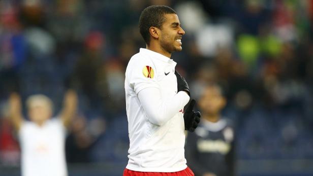 Ein lächelnder Fußballspieler in weißem Trikot mit dem Europa-League-Logo.