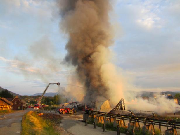 Ein Gebäude steht in Flammen, während Feuerwehrleute versuchen, den Brand zu löschen.