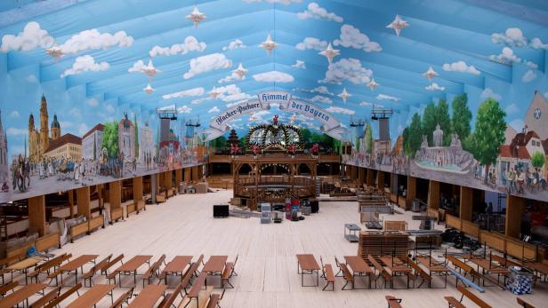 Blick in das leere Hacker-Pschorr-Festzelt auf dem Oktoberfest mit bemalten Wänden und Tischen.