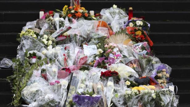 Blumen, Kerzen und Nachrichten auf den Stufen eines Gebäudes.