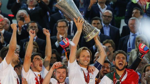 Fußballspieler feiern mit der Europa-League-Trophäe.