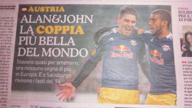 Zwei Fußballspieler von Red Bull umarmen sich auf einem Zeitungsartikel.
