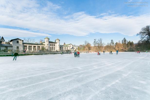 Menschen laufen auf einer Eisfläche Schlittschuh.