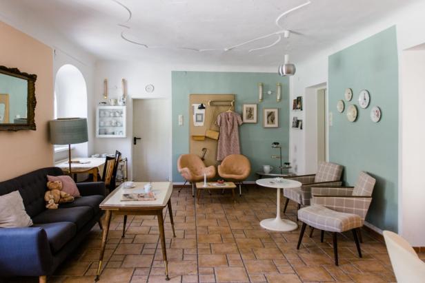 Ein Wohnzimmer im Retro-Stil mit verschiedenen Sitzgelegenheiten und Dekorationen.