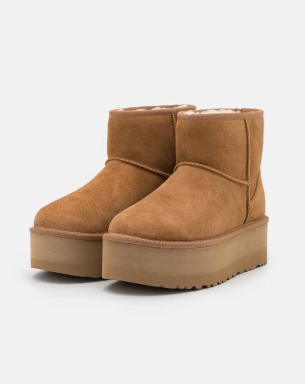 Zwei braune UGG Mini Bailey Plateaustiefel stehen vor einem neutralen Hintergrund.