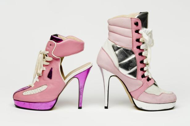 Zwei High-Heel-Schuhe im Sneaker-Stil in Rosa- und Silberfarben stehen nebeneinander.