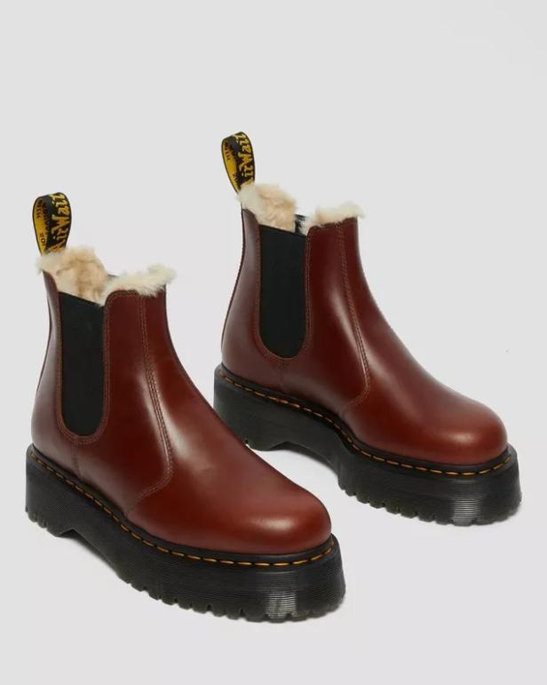Ein Paar braune Dr. Martens Chelsea Boots mit Plateausohle und Fellfutter.