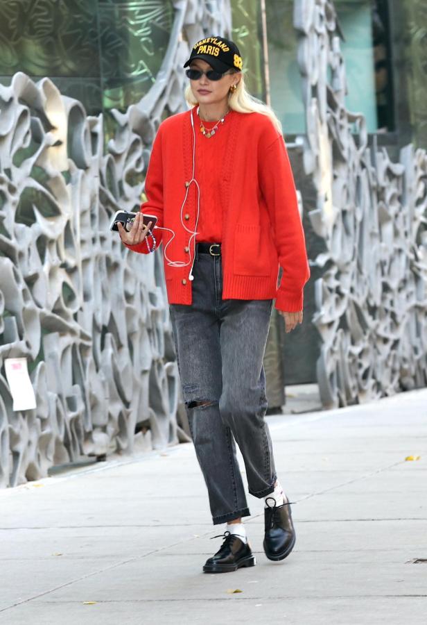 Gigi Hadid im Herbst-Streetstyle mit roter Strickjacke und „Disneyland Paris“-Kappe.