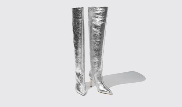 Zwei silberne Overknee-Stiefel mit Absatz stehen vor einem weißen Hintergrund.