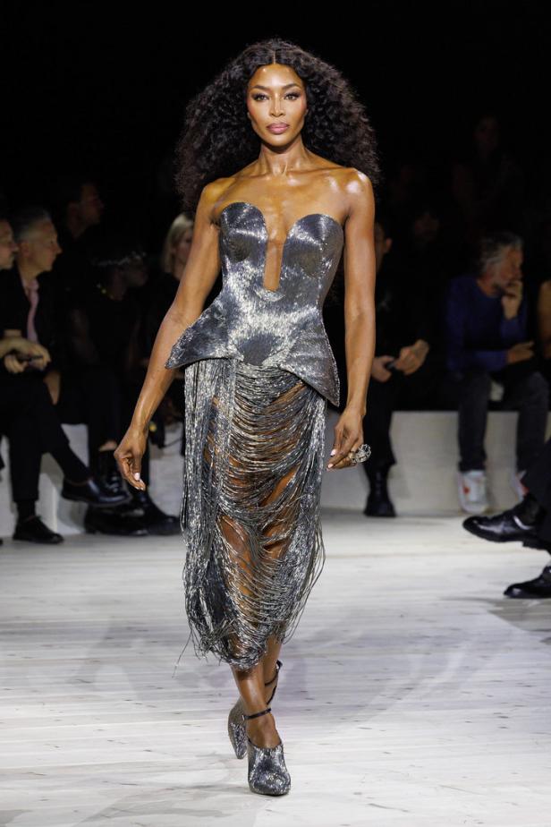 Naomi Campbell läuft in einem silbernen Kleid über den Laufsteg.