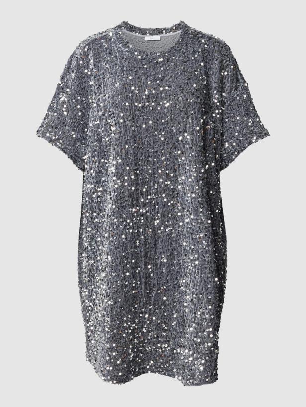 Ein graues, paillettenbesetztes T-Shirt-Kleid vor einem neutralen Hintergrund.
