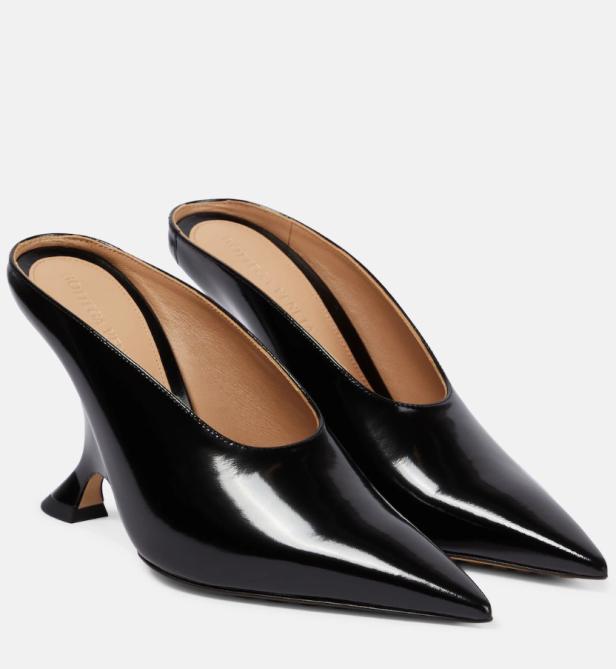 Zwei schwarze Bottega Veneta Mules mit spitzer Zehenpartie stehen auf einem weißen Hintergrund.