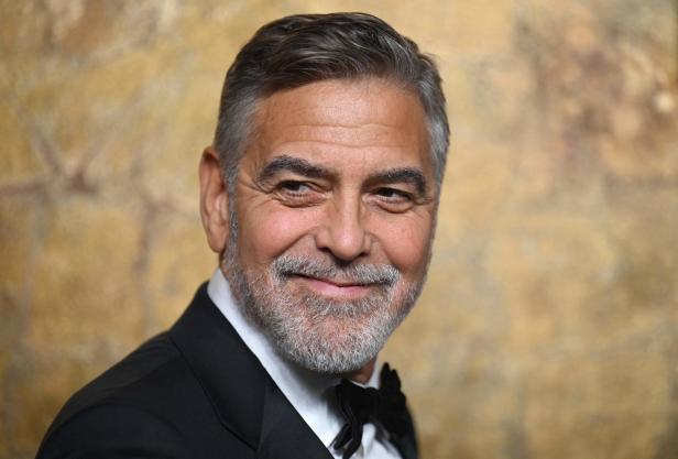 Porträt von George Clooney mit grauem Haar und Bart, gekleidet in einen Smoking.