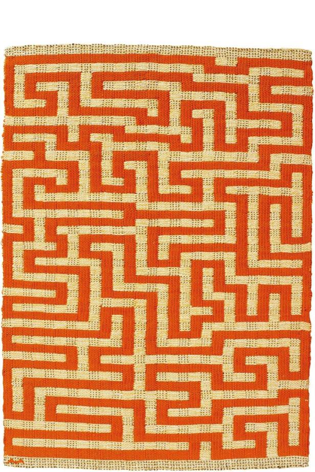 Ein Teppich mit einem orangefarbenen Mäandermuster auf beigem Grund.