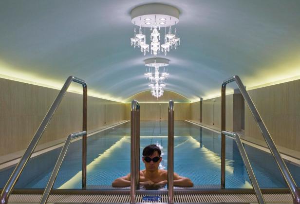Ein Mann mit Schwimmbrille lehnt im Pool des Sans Souci.