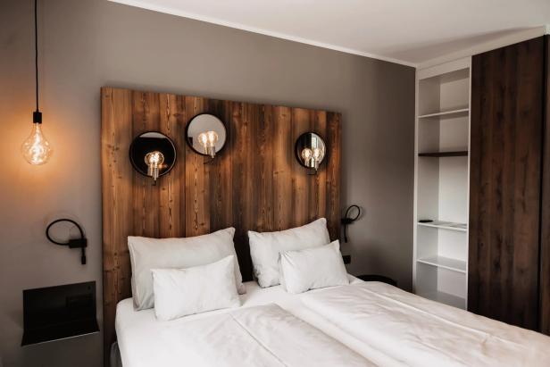 Ein Schlafzimmer mit einem Holzbett und dekorativen Lampen.
