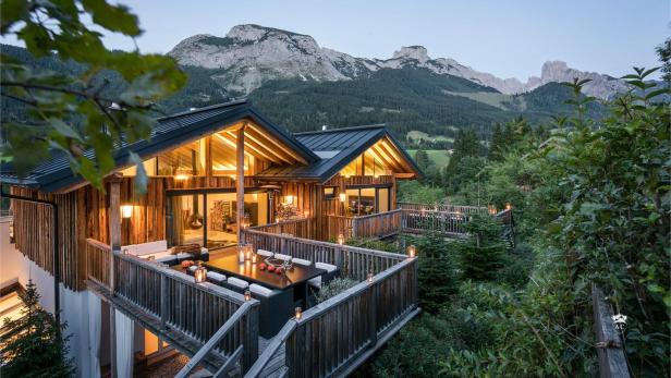 Chalet beleuchtet mit Bergen im Hintergrund.