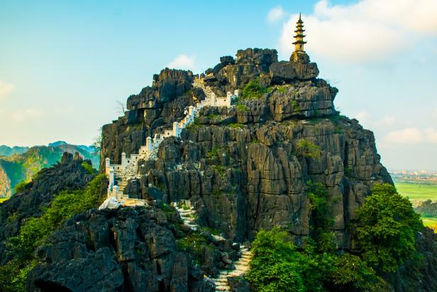 Eine Pagode auf einem steilen Felsen, erreichbar über eine lange Treppe.