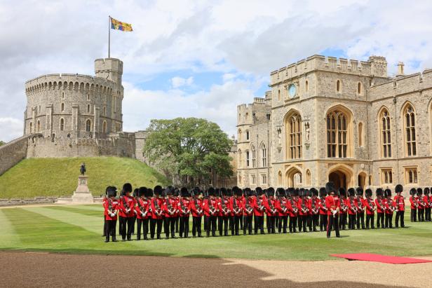 Eine Reihe von königlichen Gardesoldaten steht vor Schloss Windsor.