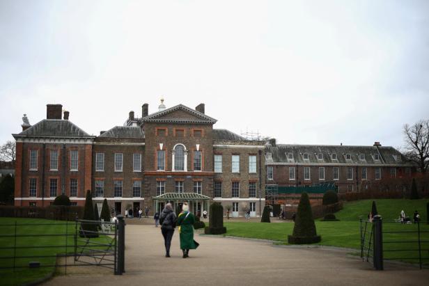 Zwei Personen gehen auf das Kensington Palace zu.