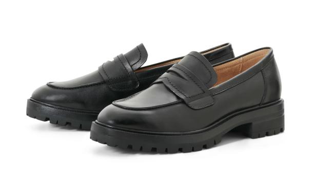 Zwei schwarze Penny Loafer mit dicken Sohlen stehen auf einem weißen Hintergrund.