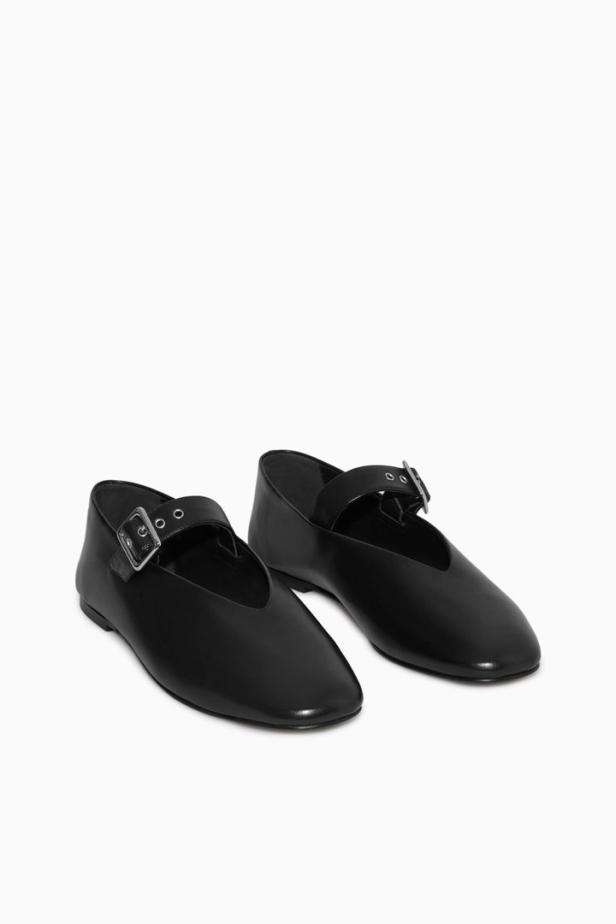 Zwei schwarze Mary-Jane-Schuhe mit Schnalle stehen auf einem weißen Hintergrund.