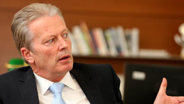 Ein Mann im Anzug schaut aufmerksam zur Seite.