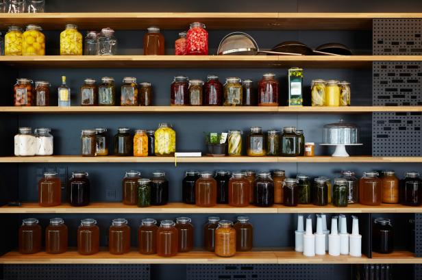 Regale gefüllt mit Einmachgläsern verschiedener Lebensmittel.