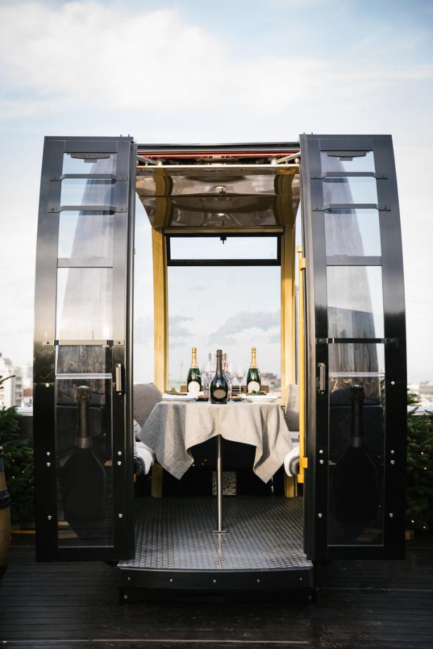 Eine Gondel ist als privater Essbereich mit Champagnerflaschen und Gläsern auf einem Tisch hergerichtet.