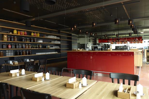 Ein Restaurant mit gedeckten Tischen und einer roten Bar im Hintergrund.