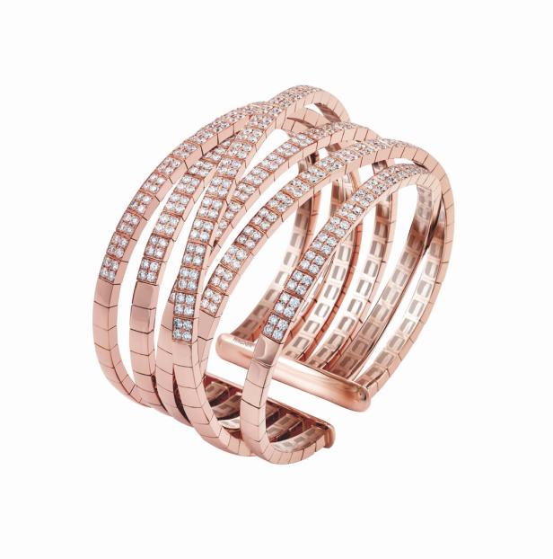 Ein roségoldener Armreif mit mehreren Reihen von Diamanten auf einem weißen Hintergrund.