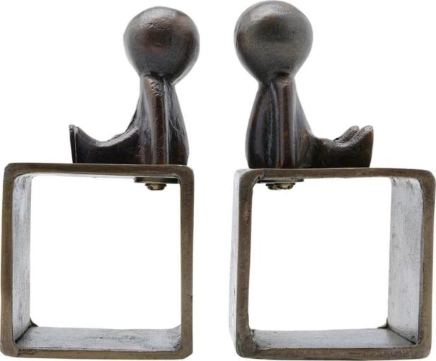 Zwei bronzefarbene Buchstützen in Form stilisierter, sitzender Figuren.