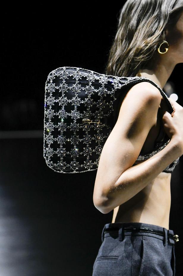 Eine Frau mit einer mit Strasssteinen besetzten Gucci-Tasche aus der Frühjahrskollektion 2024.