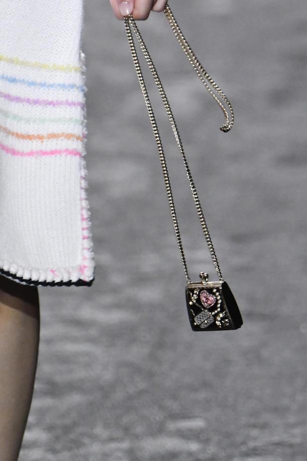 Eine Miniatur-Handtasche von Chanel aus der Frühjahrskollektion 2024 hängt an einer Kette.
