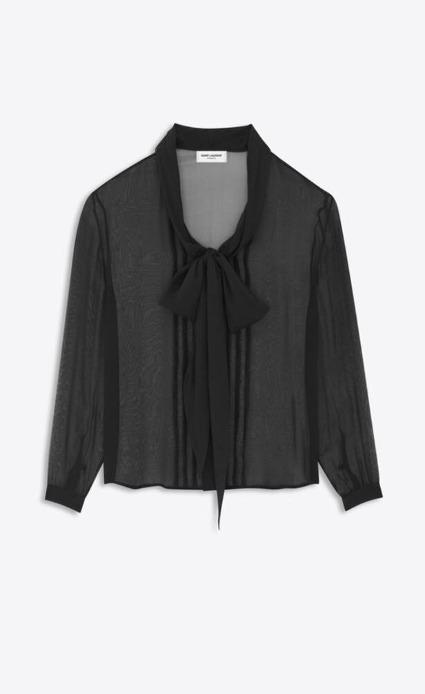 Eine durchsichtige, schwarze Bluse mit einer Schleife am Kragen.