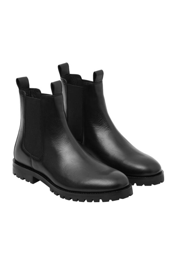 Ein Paar schwarze Chelsea Boots aus Leder stehen nebeneinander.