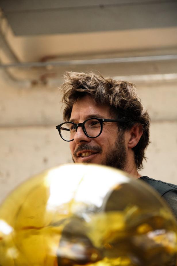 Robert Comploj mit Brille hinter einem gelben Glasobjekt