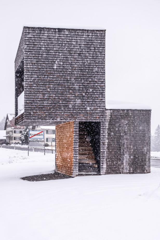 Ein modernes, holzverschindeltes Gebäude im verschneiten Krumbach.