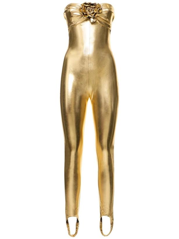 Ein goldener, trägerloser Catsuit mit einer großen goldenen Rose am Dekolleté.