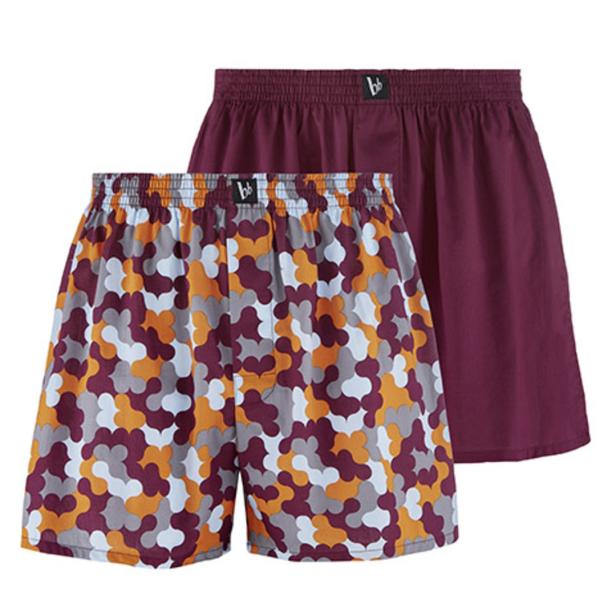 Zwei Boxershorts, eine mit Muster und eine in schlichtem Weinrot, sind zu sehen.