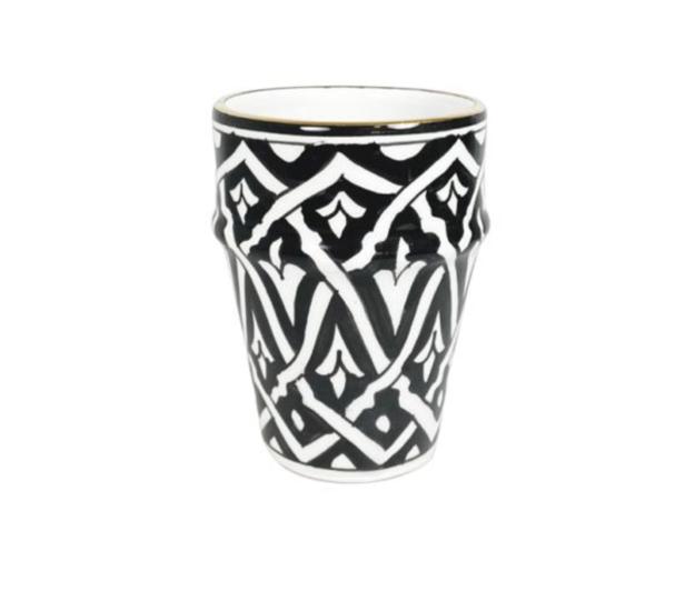 Ein marokkanisches Teeglas mit schwarzem Muster auf weißem Grund.