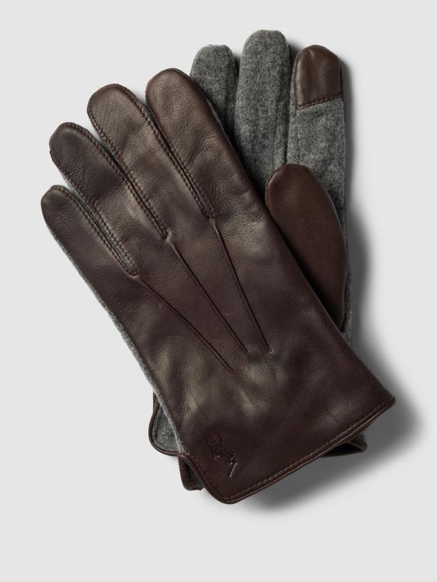 Ein Paar braune Lederhandschuhe mit grauen Wollfingern liegen auf einem hellen Hintergrund.