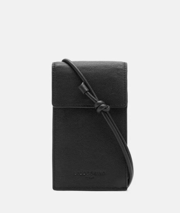 Eine kleine, schwarze Handytasche der Marke Liebeskind mit einem schmalen Trageriemen.