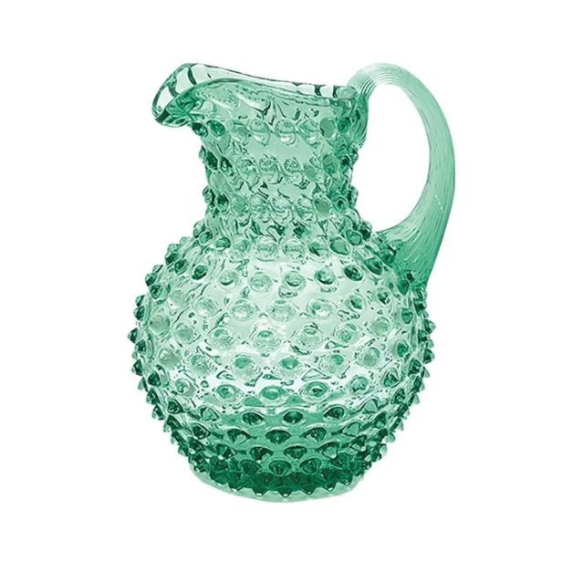 Ein grüner Krug aus Glas mit Noppenmuster.
