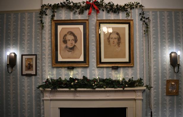 Ein dekorierter Kamin mit Porträts von Charles Dickens und seiner Frau Catherine.