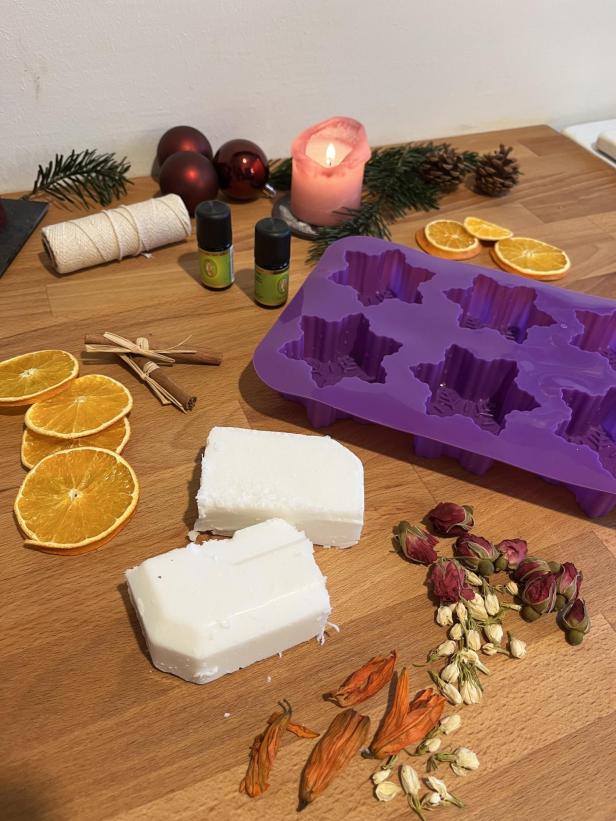 Zutaten und eine Sternform für die Herstellung von Weihnachtsseife liegen auf einem Tisch.