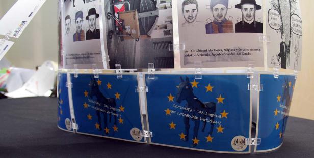 Ein zylindrisches Objekt zeigt Bilder und Texte zu Themen wie Deutschland und Europa.
