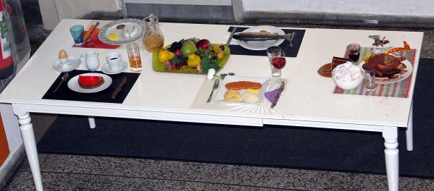 Ein gedeckter Tisch mit verschiedenen Speisen, darunter Fisch, Fleisch und Obst.