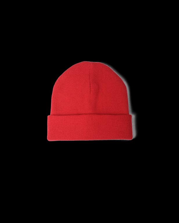 Eine rote Strickmütze vor schwarzem Hintergrund.