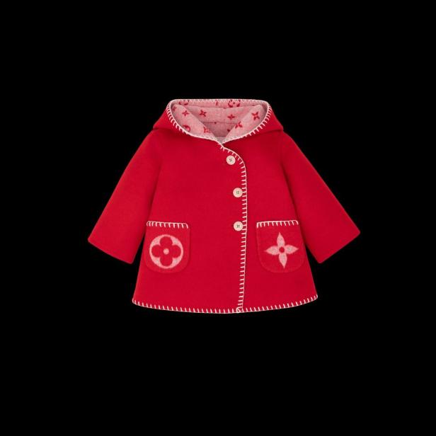 Ein roter Kindermantel mit Kapuze und weißen Ziernähten.